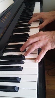 Mains de Patrick Issarni, professeur de piano, sur le clavier de son piano